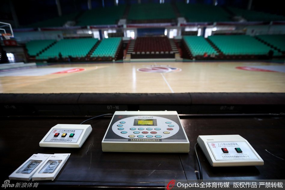 技术人员弯下腰，目光专注地审视着计时器控制主机背后的复杂线路，手中的螺丝刀轻轻调整着接口，仿佛外科医生在进行一场精密的手术，确保电子信号的每一次跳动都准确无误。