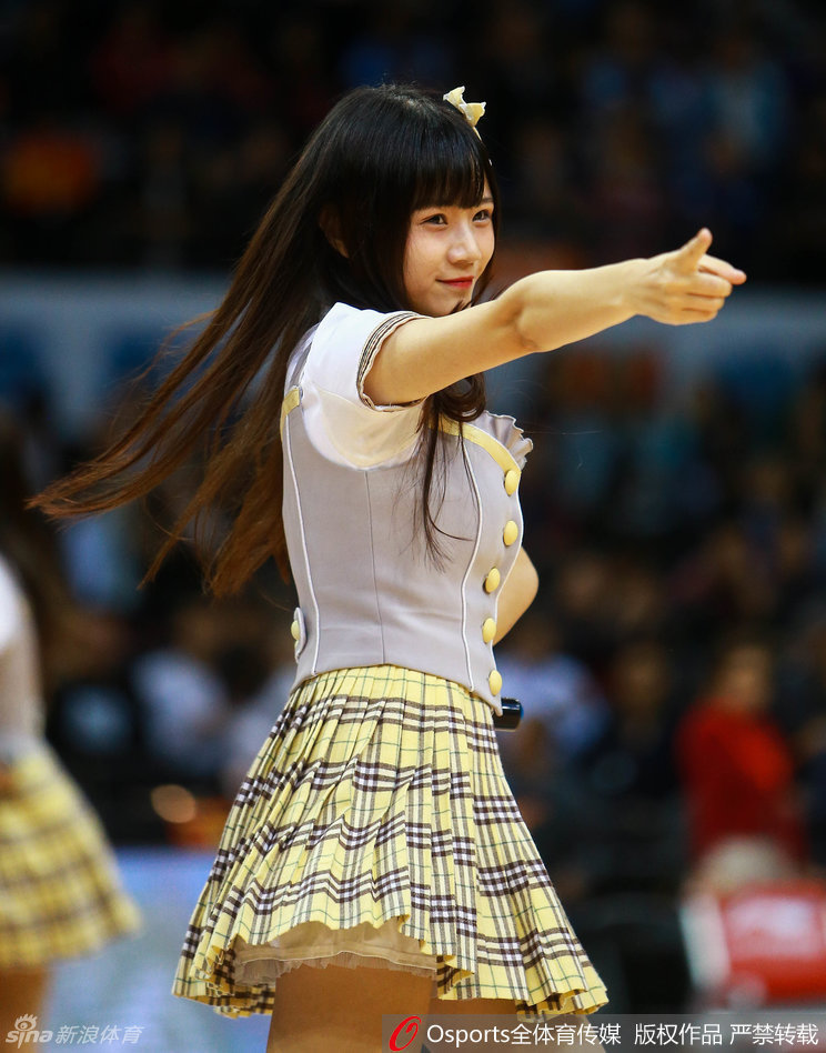 候场区里,女孩们相互整理着衣领和头发,专注的眼神中透露出对这次表演的重视,她们要把最完美的一面献给现场的篮球迷。