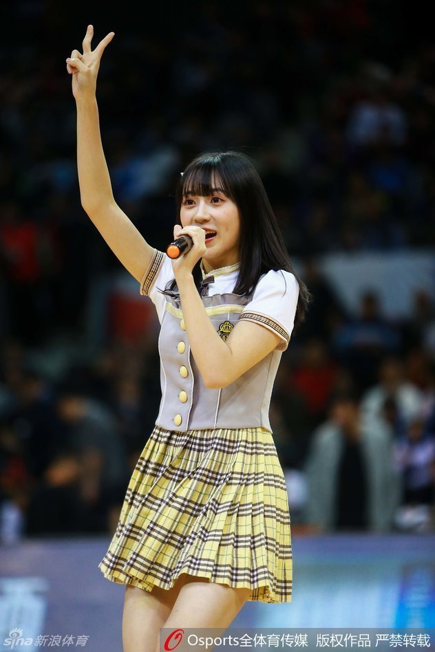 一位扎着双马尾的成员正在压腿热身,认真的侧脸在赛场灯光的照耀下显得格外动人,尽显少女偶像的灵动与可爱。