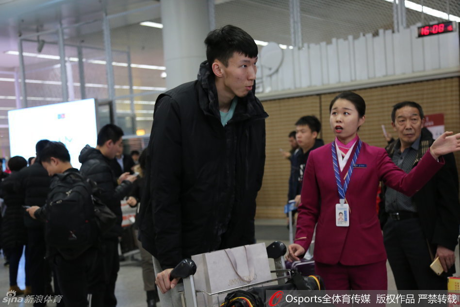 内线支柱周琦面带微笑走出机场通道，高大的身影在人群中格外醒目，他正向热情的接机球迷挥手致意。