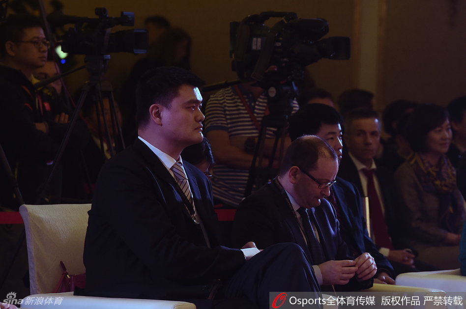 中国篮协主席姚明在发布仪式上手持话筒发言，身后的大屏幕映出会徽的图案，他神情专注而坚定