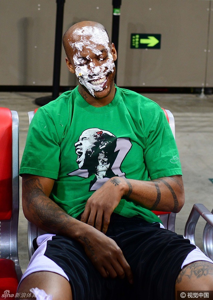 面对多人的围攻,这位满脸奶油的朋友虽然处于劣势,但依然笑得开怀,享受着这多对一的甜蜜攻击。