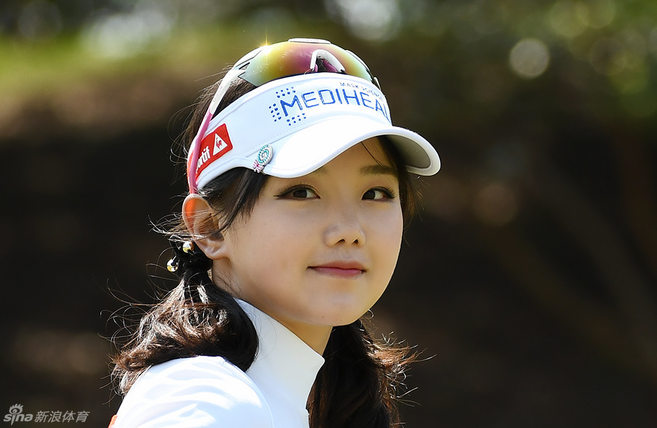 石昱婷身着白色运动服,在练习果岭边全神贯注地进行推杆练习,阳光洒在她认真的侧脸上。