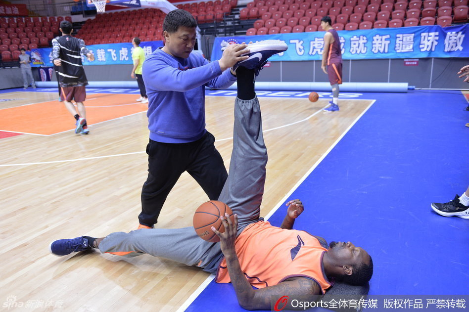 灵活的胖子布莱切在体能师协助下，龇牙咧嘴地进行着韧带拉伸，表情夸张得像在表演喜剧，引得一旁的周琦忍俊不禁。