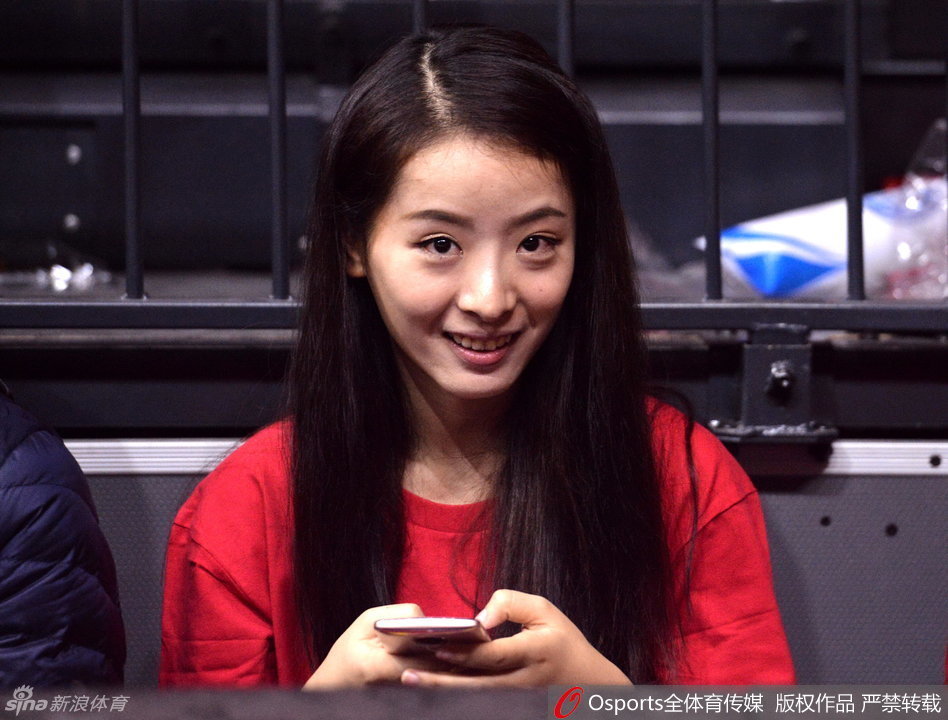 孙桐林的妻子身着优雅便装,目光温柔地追随者球场上的丈夫,嘴角藏着一丝不易察觉的紧张与期盼。