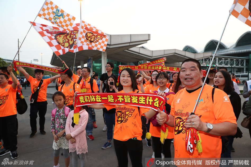 面带微笑的朱芳雨虽然难掩长途飞行的倦色，但面对热情的球迷，他依然耐心地停下脚步，在照片上认真签名。