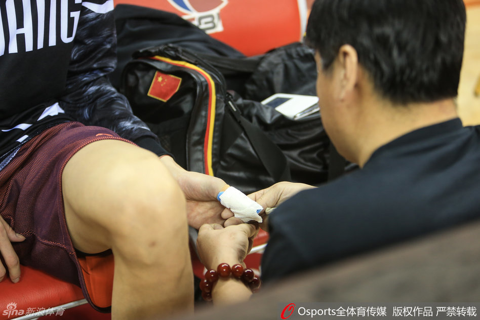 训练间歇，周琦向队医展示受伤的左手，并接受检查，确认伤处情况，面露些许不适