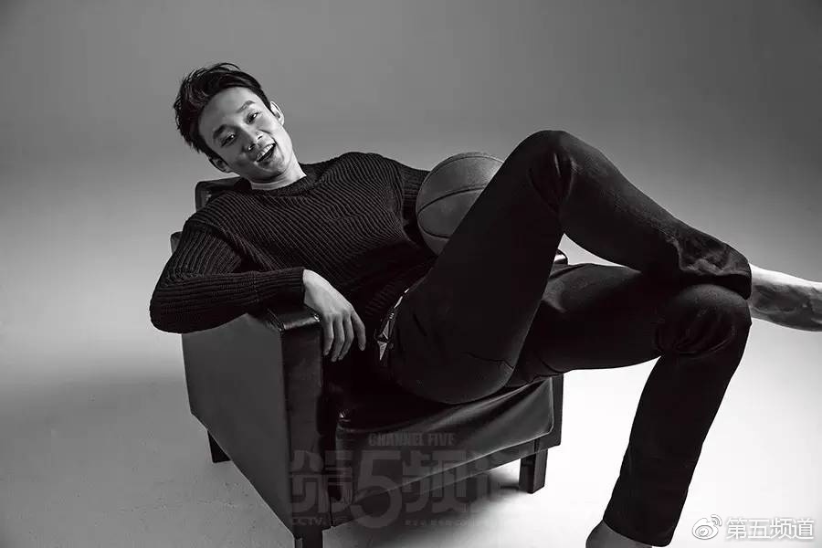 丁彦雨航站在空旷的场馆内，身穿深色运动上衣，双手插兜姿态放松，但眉宇间依然保持着运动员特有的英气，尽显成熟魅力。