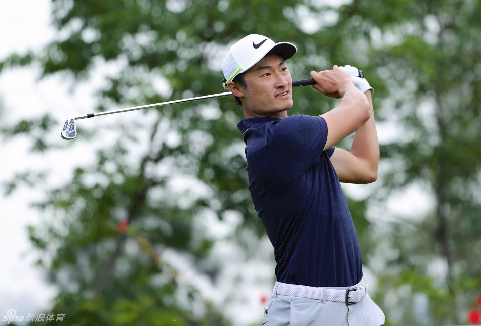 李昊桐在果岭边仔细查看推杆线路，神情专注，仿佛在脑海中预演小白球的滚动轨迹。