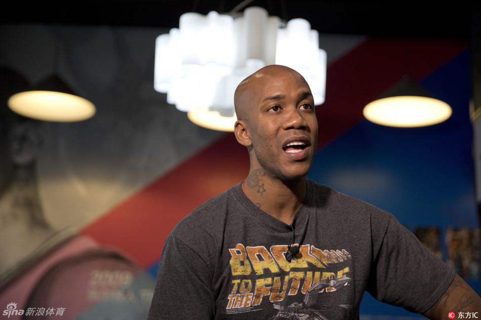 神情专注的马布里在博物馆内接受专访，他用手比划着，正在向记者解释着什么，身后的展柜里，记录着他在北京队的辉煌时刻。