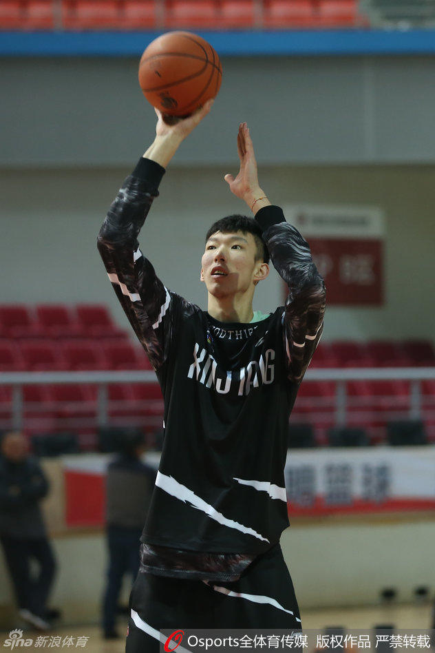 周琦在训练间隙拉伸身体，他那修长的手臂高高扬起，巨大的手掌仿佛能遮蔽天空，这位“大魔王”的防守威慑力将是新疆取胜的关键。