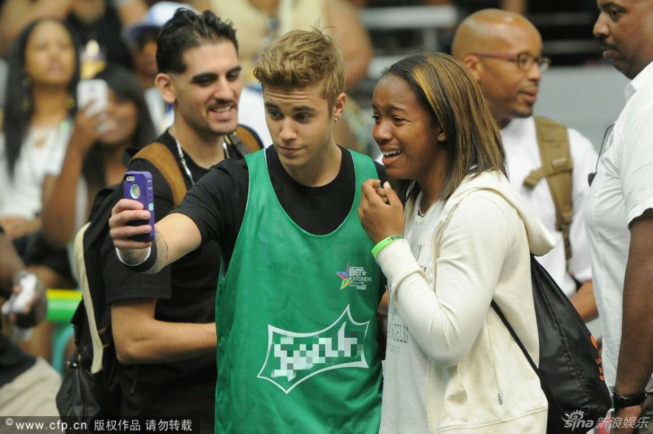 组图:比伯打篮球模仿乔丹 身高略欠不忘耍帅