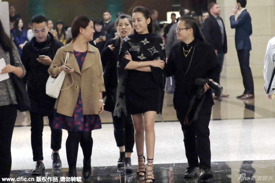 迪丽热巴穿着短裙,秀出细长美腿,披着披肩,身旁助理左右护驾,一副御姐