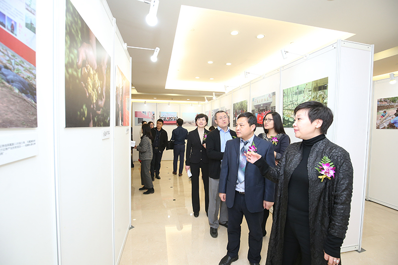 图为参会嘉宾正在参观金融企业扶贫摄影作品。