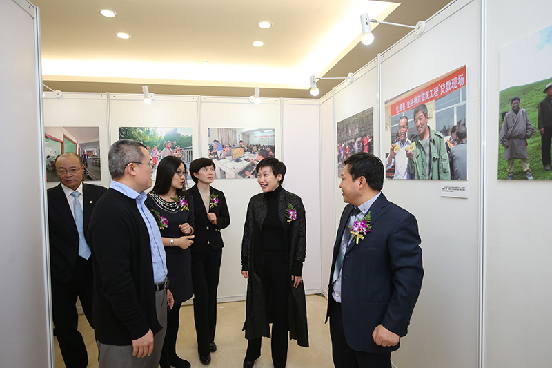 参观金融企业扶贫摄影作品。图为参会嘉宾就展出作品正热烈交流。