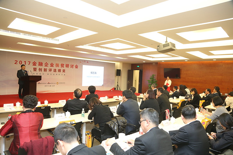 金融企业扶贫研讨会监管会领导致辞环节。图为中国证监会办公厅扶贫办副主任杨志海正发表致辞，现场气氛热烈，座无虚席。