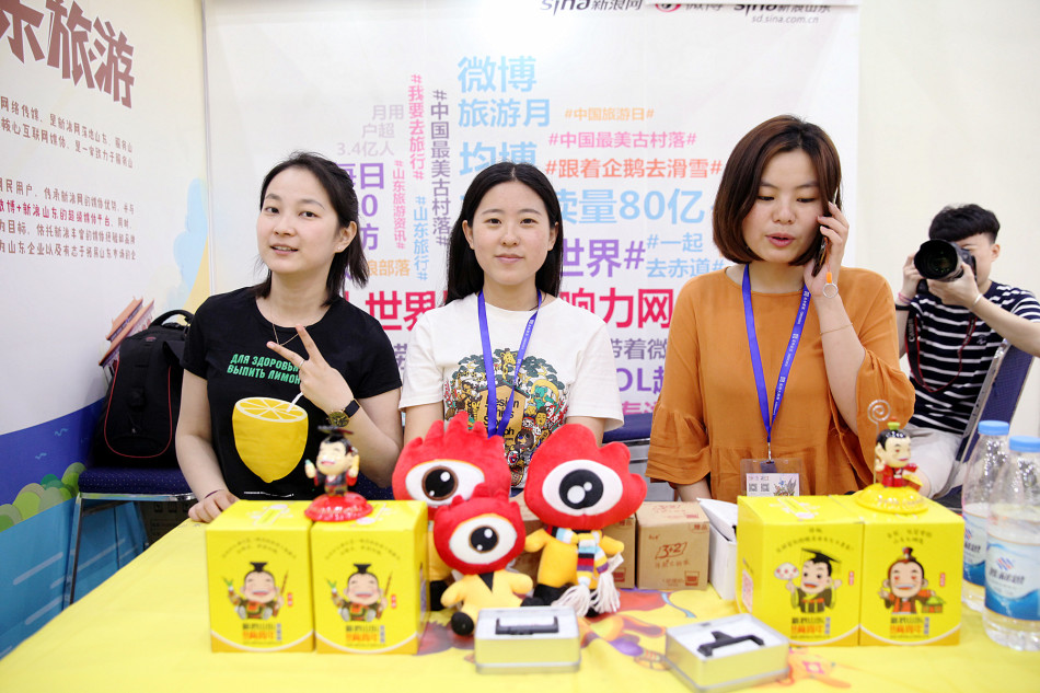 展区摆放了众多新浪公仔、车载支架等趣味周边，还有照片打印机，引得游客纷纷驻足。（图片摄影：@斩云剑）