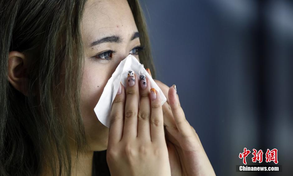 图为29日彩排后，由于出了太多汗，槟语在用纸巾擦脸。她的指甲是专门根据这次showgir的“猫”主题涂的。上海气温居高不下，最近连续几天都在35度以上。中新社发 张浩 摄