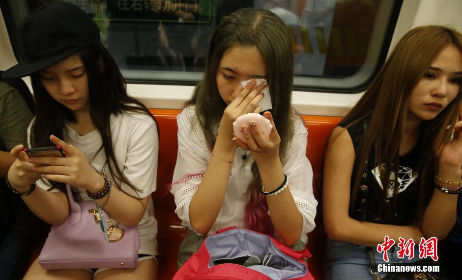 图为29日晚，槟语在地铁里卸妆。中新社发 张浩 摄