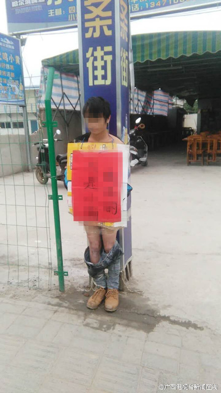 捆绑在路边的柱子上,胸前还被人写上了"我是小偷该死的"字样据被偷