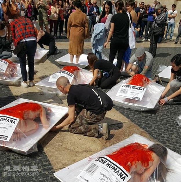 许多血腥"盒装人肉"摆在广场上,示威者脱下衣服,在身上涂假血,趴在