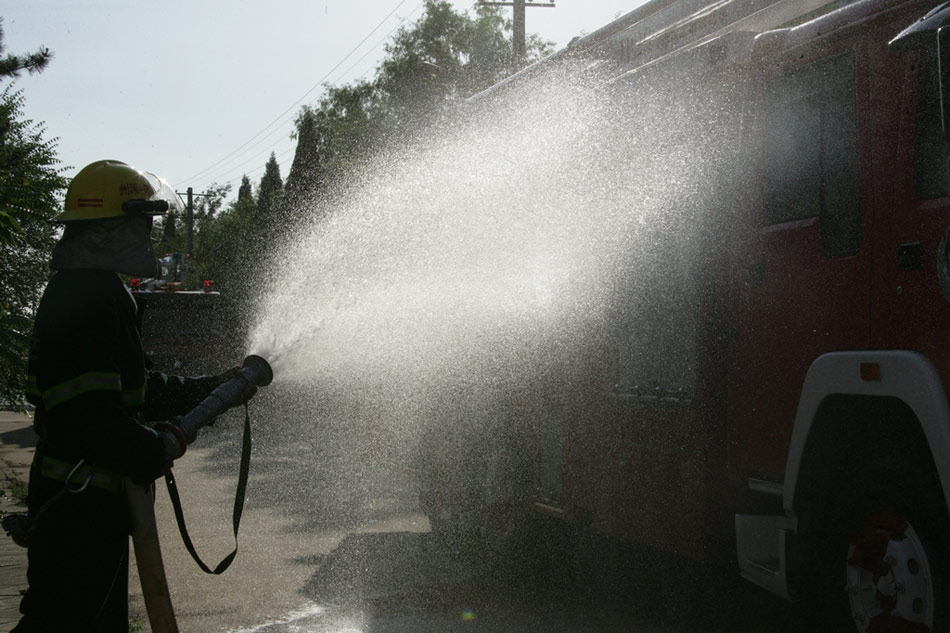 消防武警身着防护服清洗消防车辆