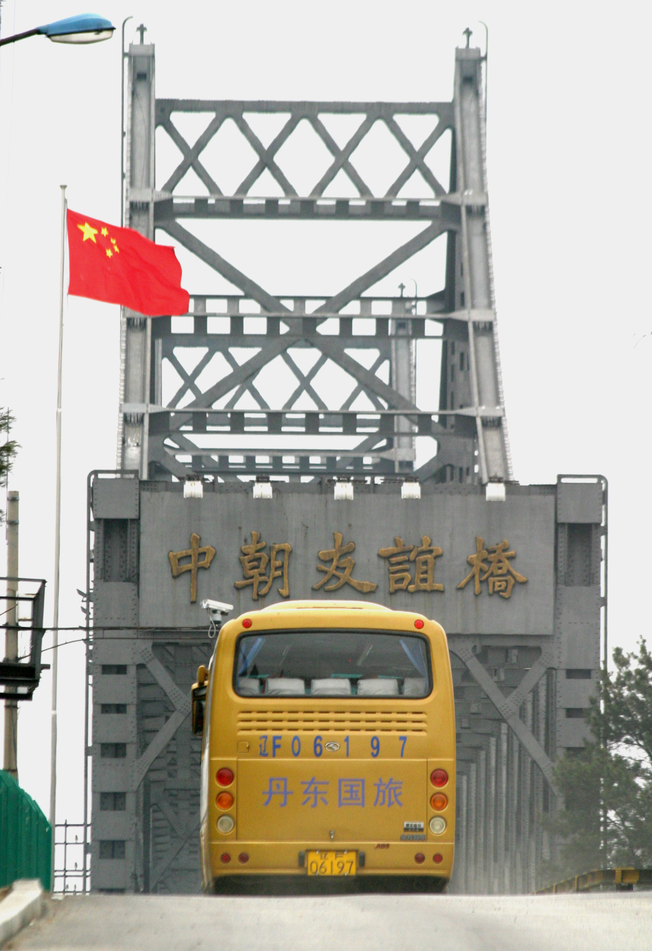 4月12日,在辽宁丹东口岸,赴朝首发团游客向送别的人们挥手告别