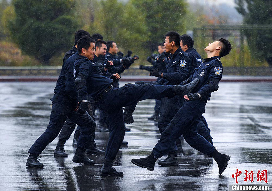 在该市特警八支队驻地,特警队员在雨中苦练擒敌拳,倒功,格斗术,硬气功