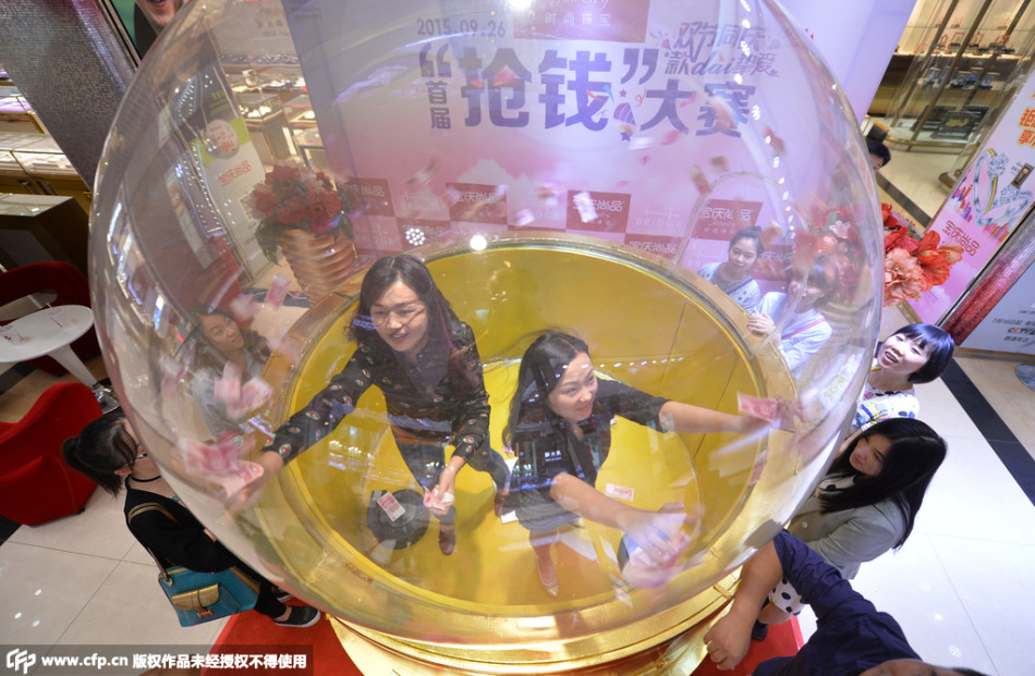 位选手正疯狂地抢着漫天飞舞的钞票,在规定时间内抓钱最多的最终胜者