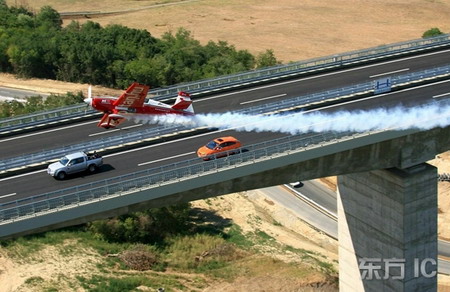 组图：特技飞行员驾机与汽车竞速