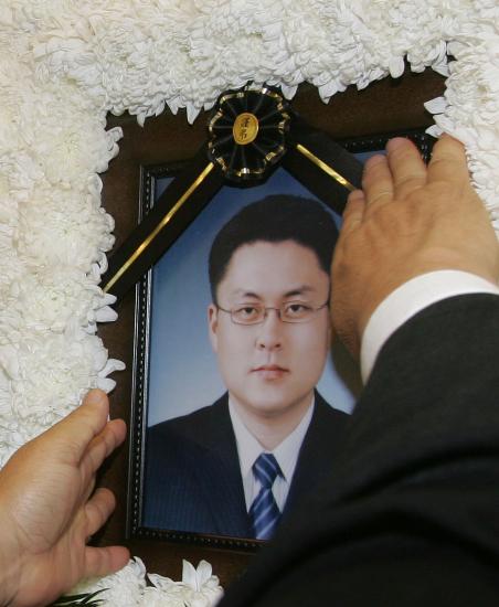 图文:被害人质父亲在灵堂前抚摸儿子照片