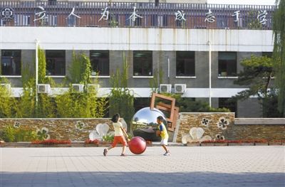 8月15日,清华附小,两名学生在校园里玩耍,背后的楼上悬挂着校训“立人为本,成志于学” 8月15日,清华附小,两名学生在校园里玩耍,背后的楼上悬挂着校训“立人为本,成志于学”