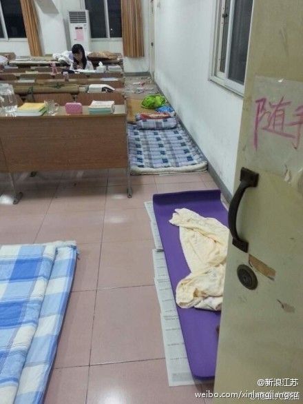 自习教室走道里铺满了席子。 自习教室走道里铺满了席子。