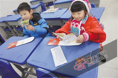 寒假成绩单大礼包里竟然装有两根棒棒糖,天台岗雅居乐小学的小学生都很高兴。(记者 许恢毅 摄) 寒假成绩单大礼包里竟然装有两根棒棒糖,天台岗雅居乐小学的小学生都很高兴。(记者 许恢毅 摄)