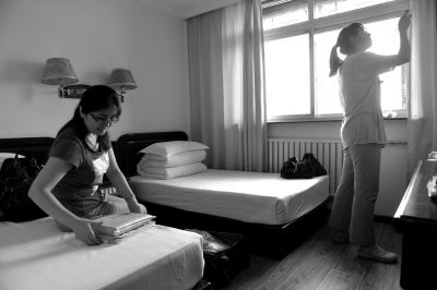 在宾馆房间内,王老师帮女儿取出复习资料。 在宾馆房间内,王老师帮女儿取出复习资料。