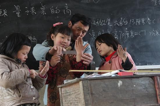2014年4月2日,湖南邵阳,隆回县三阁司镇刘辉雨老师在教3名学生用直尺测量。CFP供图(资料图片)