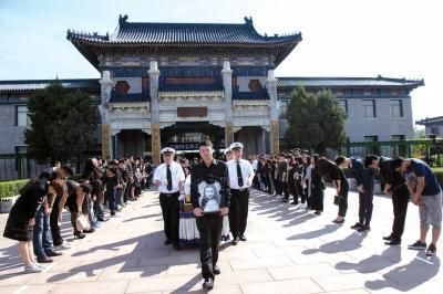 追悼会后,周云露的哥哥手捧妹妹的遗像走出灵堂,亲友及同学鞠躬送别。 追悼会后,周云露的哥哥手捧妹妹的遗像走出灵堂,亲友及同学鞠躬送别。