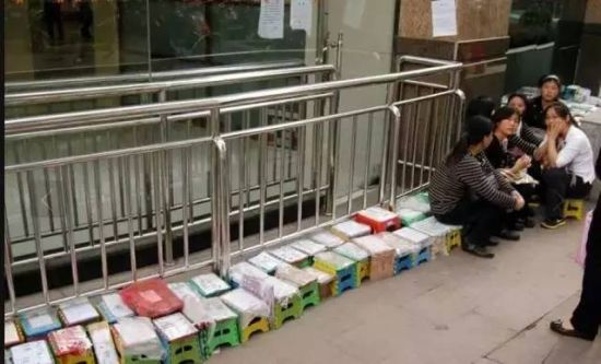 2011年9月26日,江苏省中医院门诊楼外,很多患者或家属用自制的“小板凳号”排队,只为等着能挂上专家号。小板凳上写有名字。(图片来源凤凰网) 2011年9月26日,江苏省中医院门诊楼外,很多患者或家属用自制的“小板凳号”排队,只为等着能挂上专家号。小板凳上写有名字。(图片来源凤凰网)