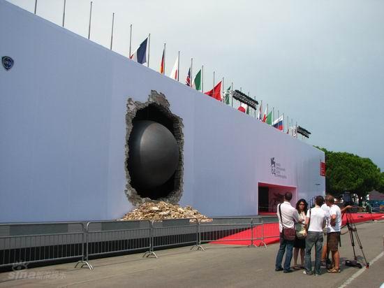 图文:威尼斯电影节红地毯上一个铁球破墙而出