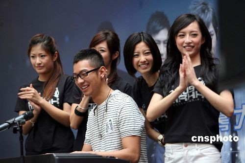 图为香港先生高钧贤登台弹奏表演，港姐周家蔚、陈自瑶在旁加油打气。 中新社发 洪少葵 摄