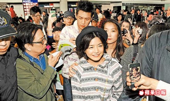 陈妍希（中）昨天（12月31日）抵达香港，看见粉丝笑容满面，柯震东则跟在她身后忙签名。