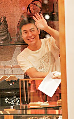 组图：许志安贴身相陪韩红购物纹身保镖随行