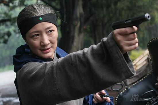 王亚君扮演的“嬷嬷”把枪举了起来,眼神充满了坏人的感觉