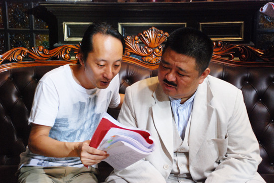 导演张家和（左）与梁冠华讨论剧本