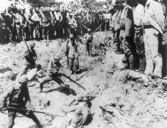 日本士兵在战壕里对被俘的中国士兵用刺刀进行刺杀，其他日本士兵则在战壕边缘观看。