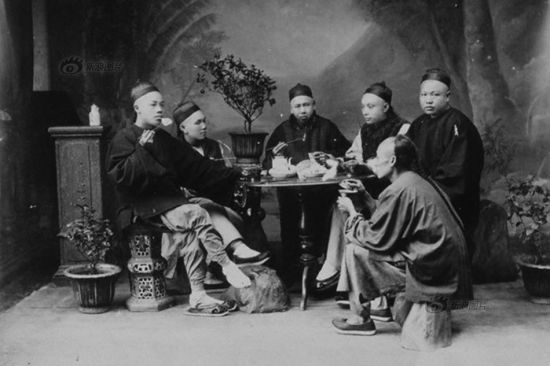 晚清,男人们围坐在桌子周围吃饭。 晚清,男人们围坐在桌子周围吃饭。