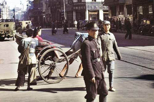 1945年，上海南京东路永安百货公司大楼附近，警察和一个士兵好奇地望着摄影师。(艾伦·拉森摄)