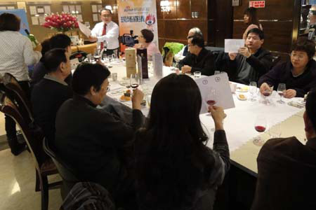 图为品酒师现场讲解分辨红酒色泽 图为品酒师现场讲解分辨红酒色泽