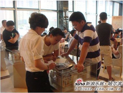 图为哈尔滨金爵万象销售中心内 置业顾问为购房者详细计算购房费用 图为哈尔滨金爵万象销售中心内 置业顾问为购房者详细计算购房费用
