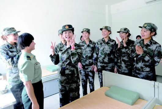 5日,几名女新兵走进军营,借老兵的军帽戴上先威风一下。(中新网 左庆 摄)